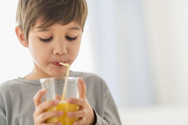 How does the water or juice move upwards through the straw while drinking?